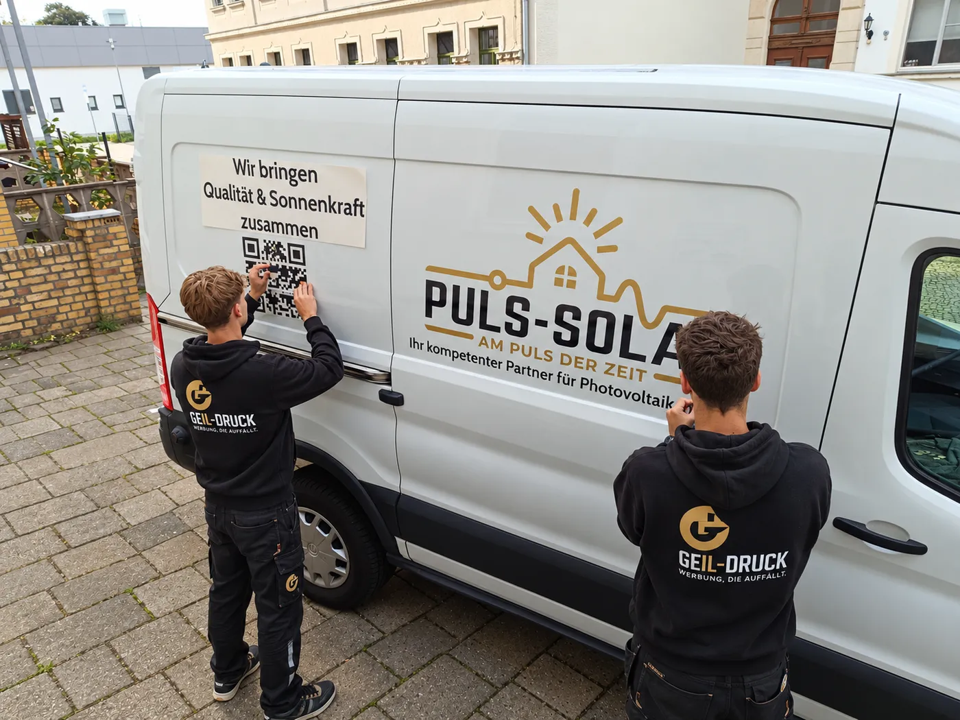 Montage einer Fahrzeugbeschriftung auf einem weißen Transporter